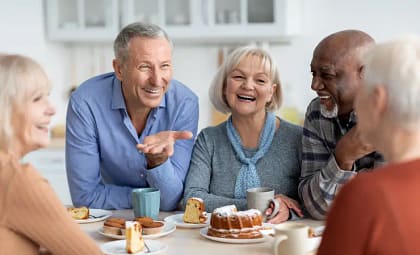 Geriatric Dentistry in Dublin, CA | Healthy Smiles for Vibrant Golden Years Seniors laughing together outdoors, holding coffee cups, with bright smiles highlighting the confidence and joy of healthy aging through quality dental care.
