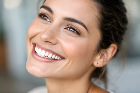 Smile Transformations & Cosmetic Dentistry | We Care Dental Confident woman smiling brightly, showcasing a radiant, transformed smile after cosmetic dentistry treatment.