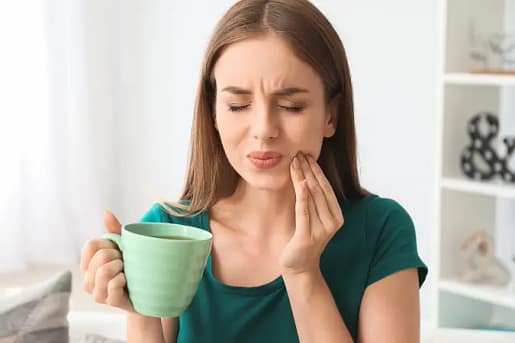 Sensitive Teeth Relief | Emergency Dentist Dublin CA | We Care Dental Woman holding her cheek in pain due to sensitive teeth, highlighting the need for emergency dental care.